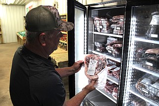 Beebe-based Homesteaders Market co-owner Dennis Bayless checks his meat stocks on Thursday, April 25, 2024 before the farmer's market officially opens on Saturday, April 27, bringing fresh local food items to Beebe residents.